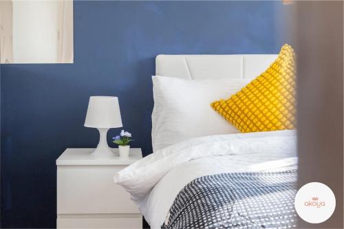 a blue bedroom with a bed with a yellow pillow at Warm and Radiant 4Bed Home Near City - Airport in Baguley