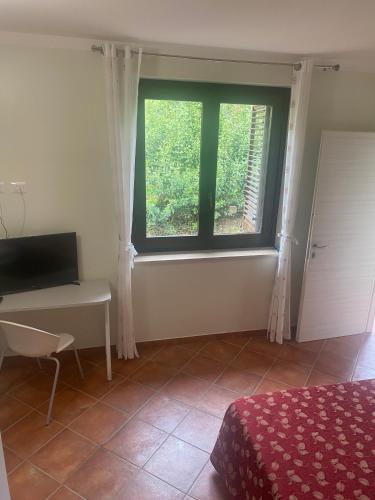 a bedroom with a bed and a desk and a window at Agriturismo La Pila in Ferentillo