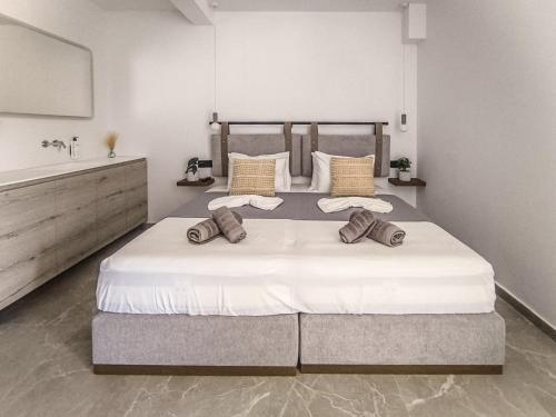 a bedroom with a large white bed with pillows at Giabeos Skiathos in Troulos