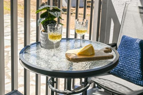 a glass table with two glasses of wine and cheese at Giabeos Skiathos in Troulos