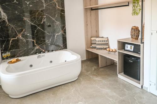 a bathroom with a white bath tub in a room at Giabeos Skiathos in Troulos
