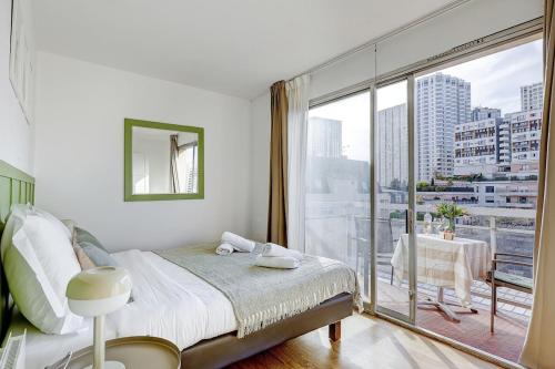 une chambre avec un lit et une grande fenêtre dans l'établissement Eiffel residence Apolline, à Paris