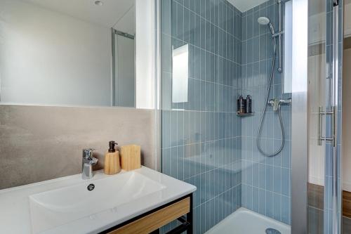une salle de bain avec un lavabo et une douche dans l'établissement Eiffel residence Apolline, à Paris