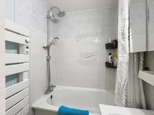 une salle de bain blanche avec une baignoire et une douche dans l'établissement T2 terrasse vue panoramique, piscine, parking, wifi, 2 tv connectées, netflix, clim, ascenseur, barbecue, à Sète