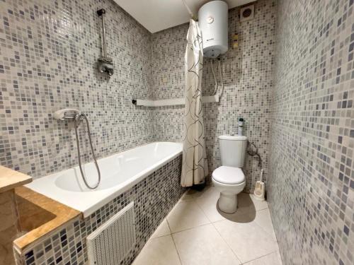 a bathroom with a tub and a toilet in it at Lumière in Marrakech