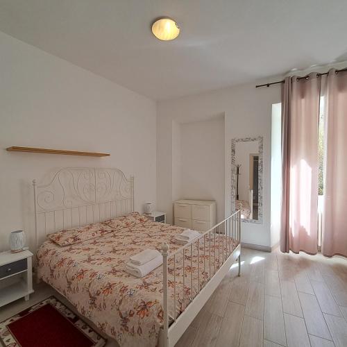 a white bedroom with a bed and a window at Da Vinci Refuge 1 in Limonta