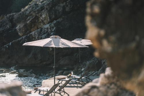 two chairs and an umbrella on a beach at La Mer Beach Residence in Ulcinj