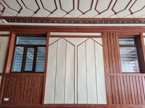 a wooden door of a house with two windows at Fazilat Guest House in Toshloq