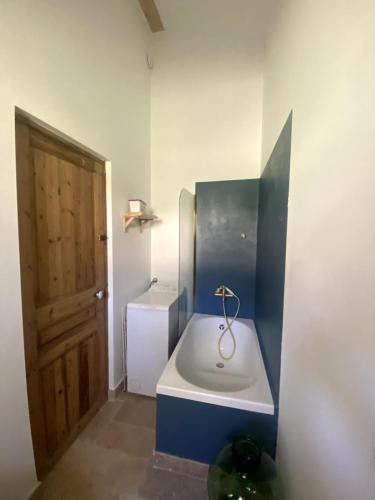 ein kleines Badezimmer mit Waschbecken und Tür in der Unterkunft Villa Augustine in Ventabren