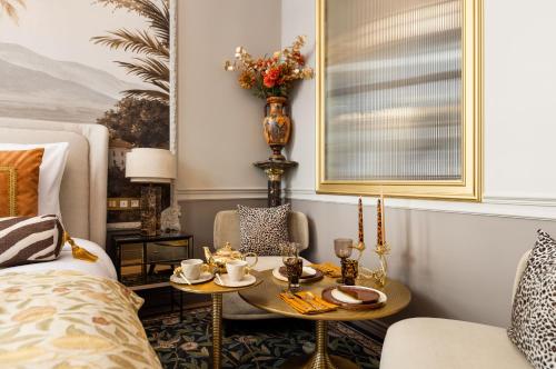 un salon avec un lit et une table avec des cafetières dans l'établissement The Donatella Suite - Champs Elysées, à Paris