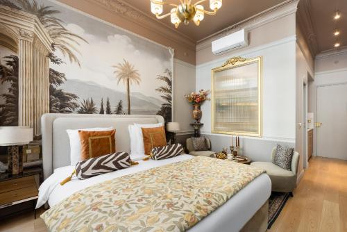 une chambre avec un grand lit et un tableau au mur dans l'établissement The Donatella Suite - Champs Elysées, à Paris