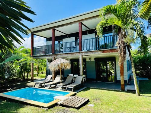 a villa with a swimming pool and a house at Le Village de la Pointe in Le Vauclin