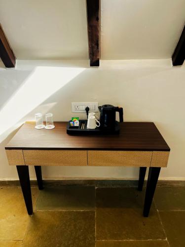 a table with a coffee maker and two glasses on it at Birds Nest Resort in Kinlivli