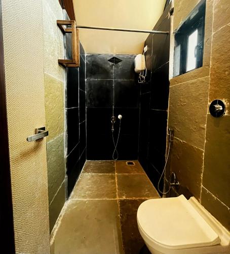 a small bathroom with a toilet and a window at Birds Nest Resort in Kinlivli
