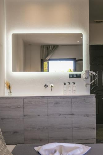 a bathroom with a large mirror on top of a dresser at Giabeos Skiathos in Troulos