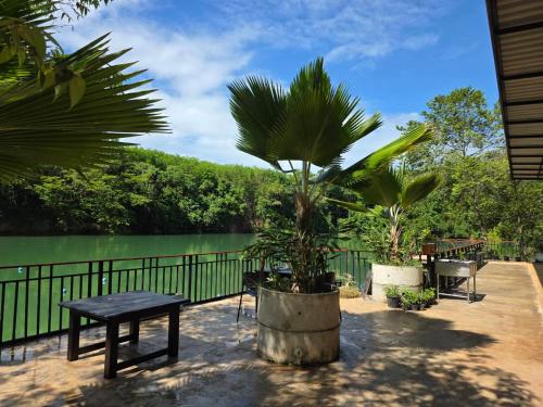 a patio with a table and a bench and a lake at Lake View Resort in Ban Nam Rop
