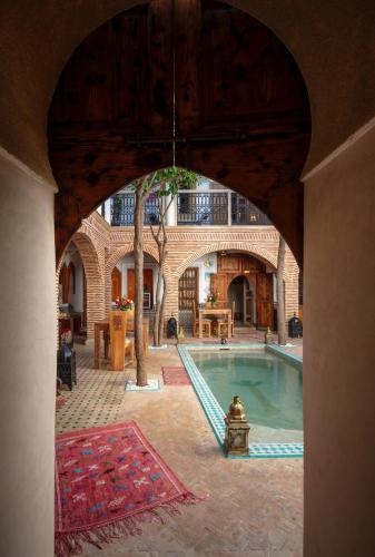 an archway in a building with a swimming pool at Riad Fleur d'Orient in Marrakech