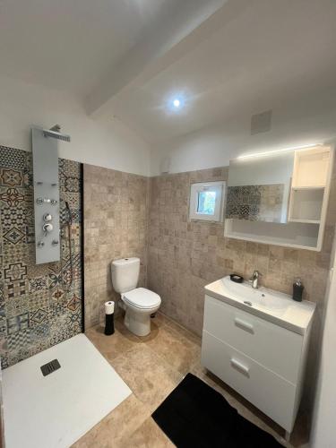 une salle de bain avec des toilettes blanches et un lavabo dans l'établissement La suite du Grand Cèdre, à Lussac