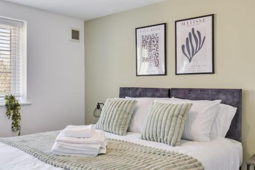 una camera da letto con un letto bianco con due cuscini di Cozy Riverside Cottage in Hertford Town with Parking a Hertford