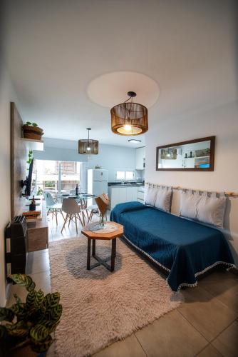 a living room with a bed and a kitchen at Río Cuarto Host in Río Cuarto