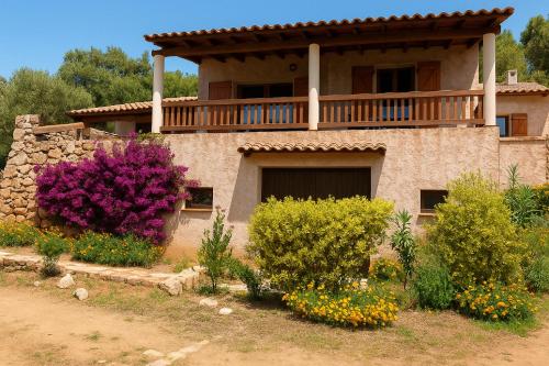 a house with a balcony on top of it at Maison Authentique Corse Vue Mer Panoramique et Nature Sauvage in Zonza