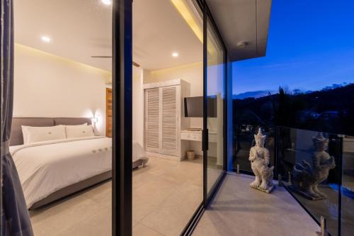 a bedroom with a bed and a large glass window at Villa Bond Seaview Villa in Chaweng Noi Beach