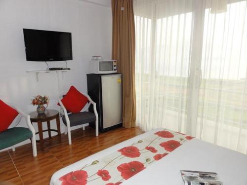 una habitación de hotel con cama y TV y una habitación en Chomdao Baan Manisa, en Kiriwong