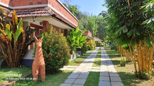 a giraffe statue standing next to a house at Holindz Holiday Villa in Panamaram