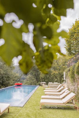a group of lounge chairs next to a swimming pool at Maison Gabrielle in Vals-les-Bains