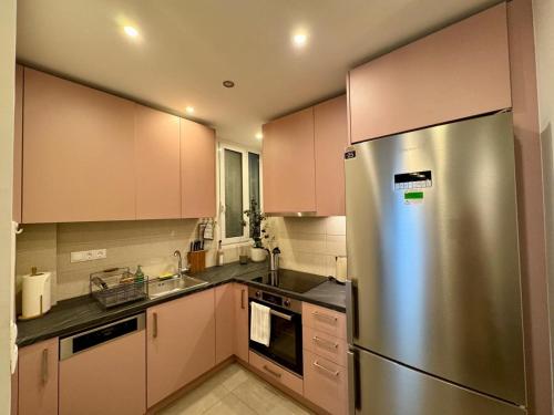 a kitchen with a stainless steel refrigerator and cabinets at Acropoli 1 Bedroom Flat with Rooftop Acropolis View in Athens