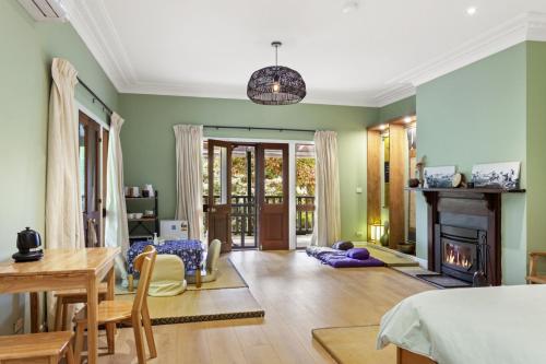 sala de estar con paredes verdes y chimenea en Birdstow Spacious peaceful Stay Sleeps Ten, en Wentworth Falls