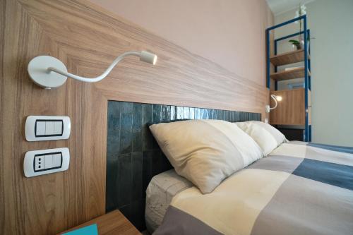 a bedroom with a bed and a light on the wall at Locanda Parsifal in Parma