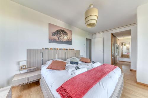 - une chambre avec un grand lit blanc et une couverture rouge dans l'établissement GuestReady - Chic Stay with Jacuzzi and Parking, à Lyon