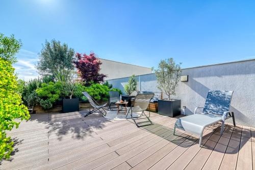 un patio avec des chaises et une table sur une terrasse dans l'établissement GuestReady - Chic Stay with Jacuzzi and Parking, à Lyon