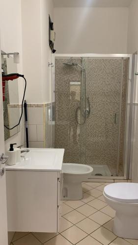a bathroom with a shower and a sink and a toilet at Home Zeus in Giardini Naxos