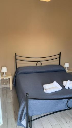 a bedroom with a bed with two towels on it at Home Zeus in Giardini Naxos