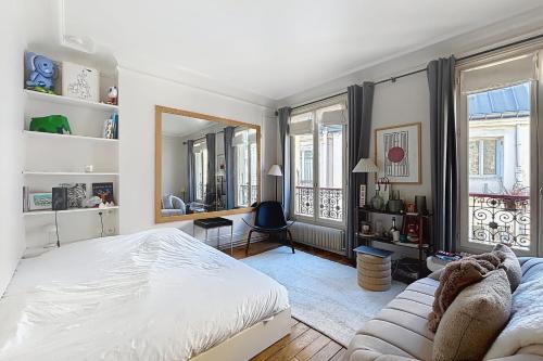 une chambre avec un lit, un bureau et un miroir dans l'établissement Charming apartment near the Eiffel Tower, à Paris