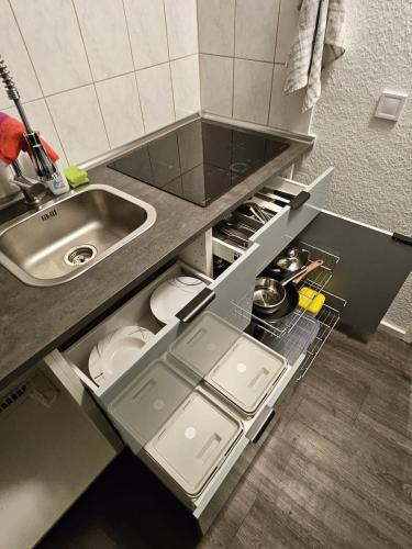 a kitchen with a sink and an open drawer at Ruhrpott Serviced Apartments in Recklinghausen