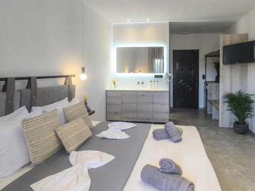 a bedroom with a bed and a sink and a mirror at Giabeos Skiathos in Troulos