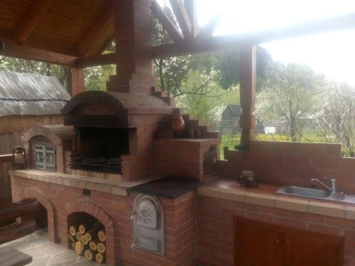 an outdoor kitchen with a brick oven on a patio at Casa Bunicii in Moisei