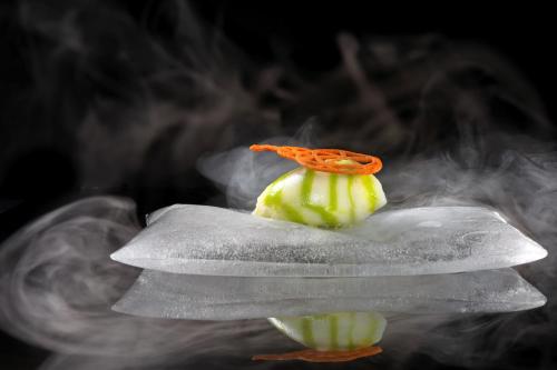 a piece of food sitting on top of smoke at Hotel Weiher Green Lake in Falzes