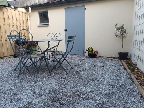 a patio with two chairs and a table in front of a building at Le 289 Audruicq in Audruicq