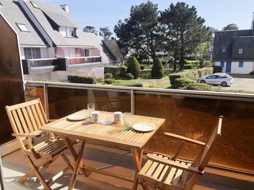 une table en bois et deux chaises sur un balcon dans l'établissement TYBI - Studio location vacances Carnac, Legenese Ty Bihan - UD220, à Carnac