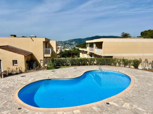 une grande piscine bleue au milieu d'une cour dans l'établissement Holidays YourHostHelper, à Cannes