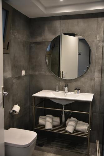 a bathroom with a sink and a mirror and a toilet at Mythical Coast Wellness Retreat in Mytilini