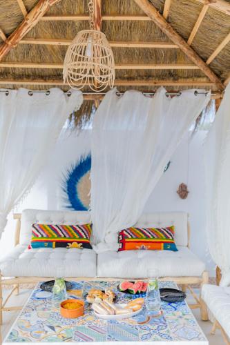 a living room with a white couch and a table at Villa Chaineze Fadhloun Djerba in Houmt Souk