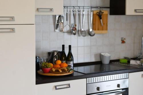 un bancone della cucina con un piatto di frutta e bottiglie di vino di Apartment Natasa a Vinišće