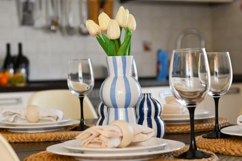 un tavolo con vaso di fiori e bicchieri da vino di Apartment Natasa a Vinišće