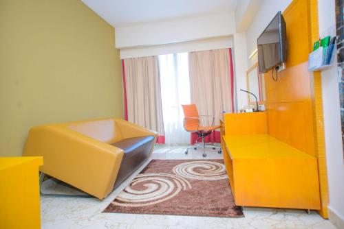 a hotel room with a yellow desk and a tv at Holiday Inn Dar Es Salaam by IHG in Dar es Salaam