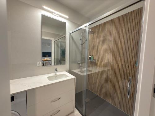 une salle de bains avec douche, lavabo et miroir dans l'établissement Baltic SEA apartament z dostępem do basenu,sauny ,jacuzzi i hali sportowej, à Gąski